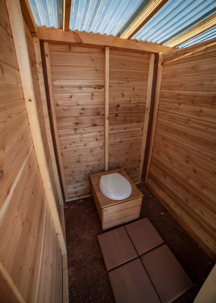 Bathroom in a tiny house with wooden walls and a composting toilet.