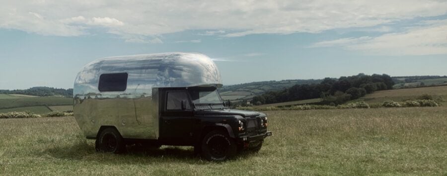 Land Rover-based motorhome parked in a scenic rural landscape, showcasing compact and versatile smal.