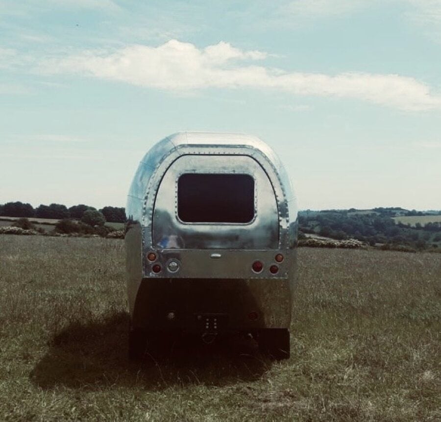 Classic Land Rover Aurochs 001 motorhome in open field under blue sky.
