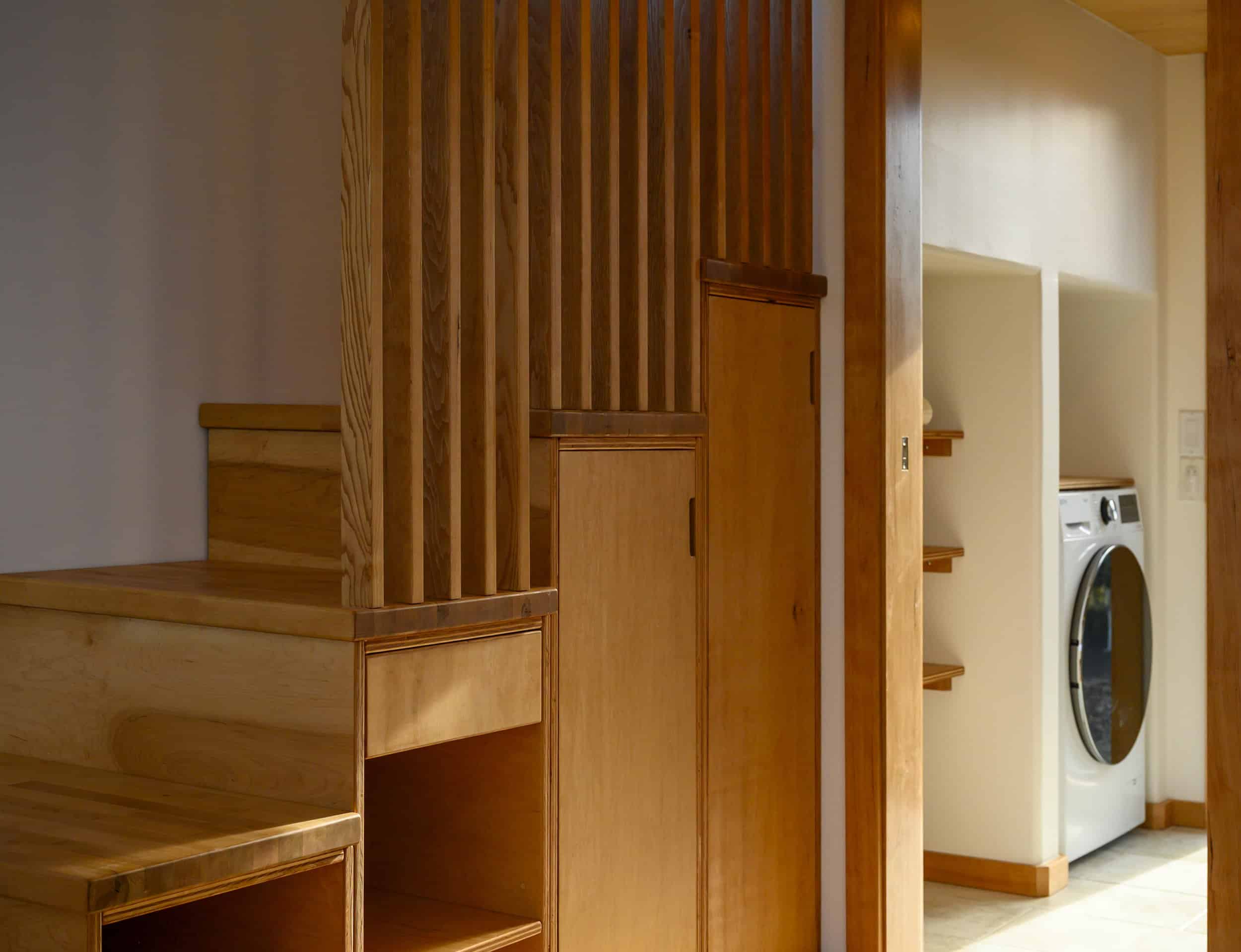 The Black Butte oak storage staircase with built-in cubbies, a fluted wood feature wall, and a Baltic birch closet