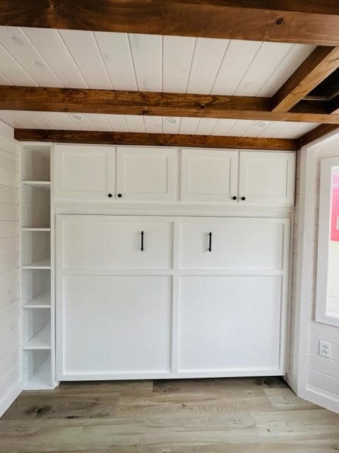 Bright white storage cabinet in a cozy tiny house interior.