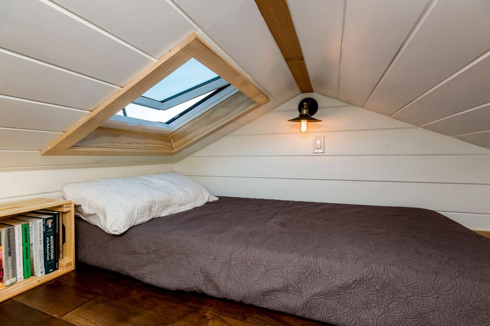 The Joshua Tree loft bedroom with a double bed, triangular skylight, and a built-in bookshelf