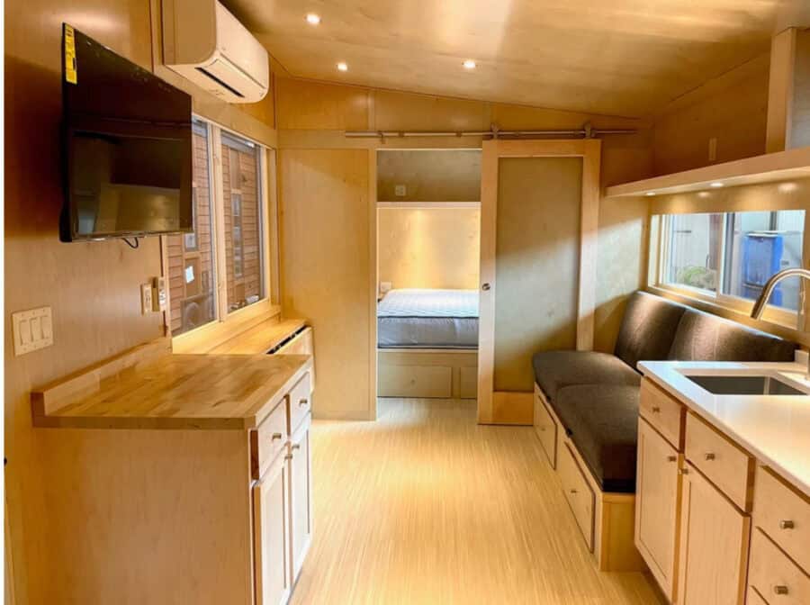 Interior view of a tiny house with a wide first-floor bedroom and compact living space.
