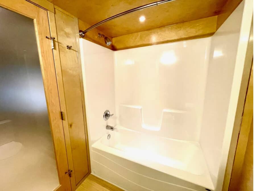Bathroom with bathtub and wooden accents in a tiny home.