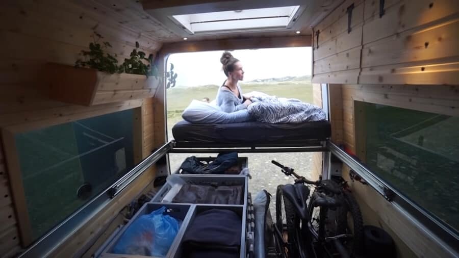 Compact van bed with beautiful wood accents and integrated storage solutions for small space living.