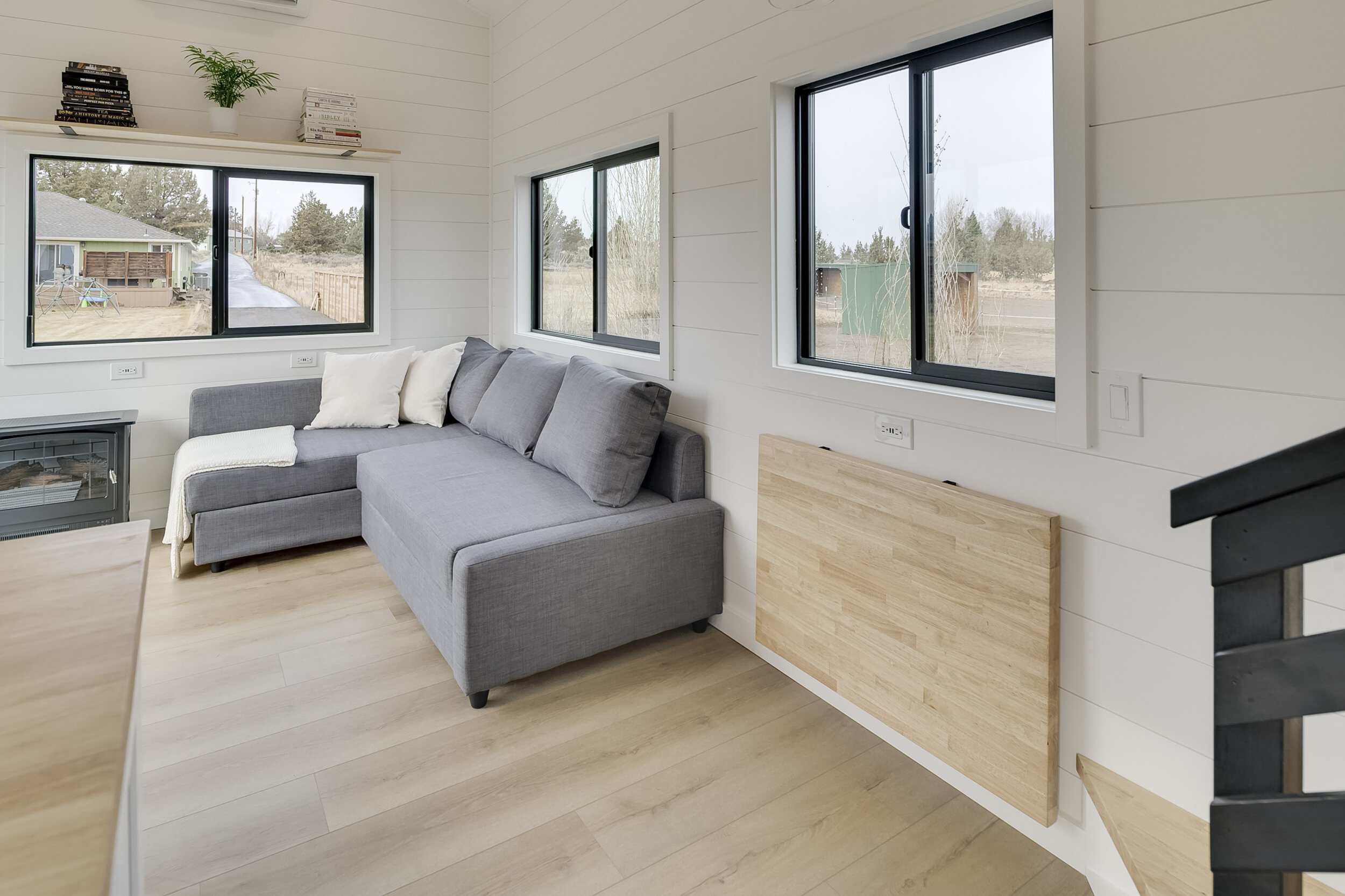 The Ochoco living room with a gray sleeper sectional, a fold-down butcher block table, and an electric fireplace