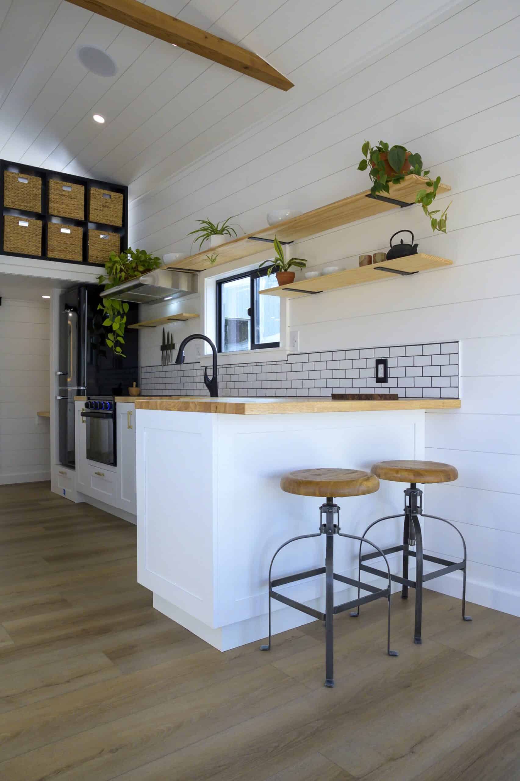 The Ochoco kitchen peninsula with two bar stools and butcher block counter dividing the kitchen and living room