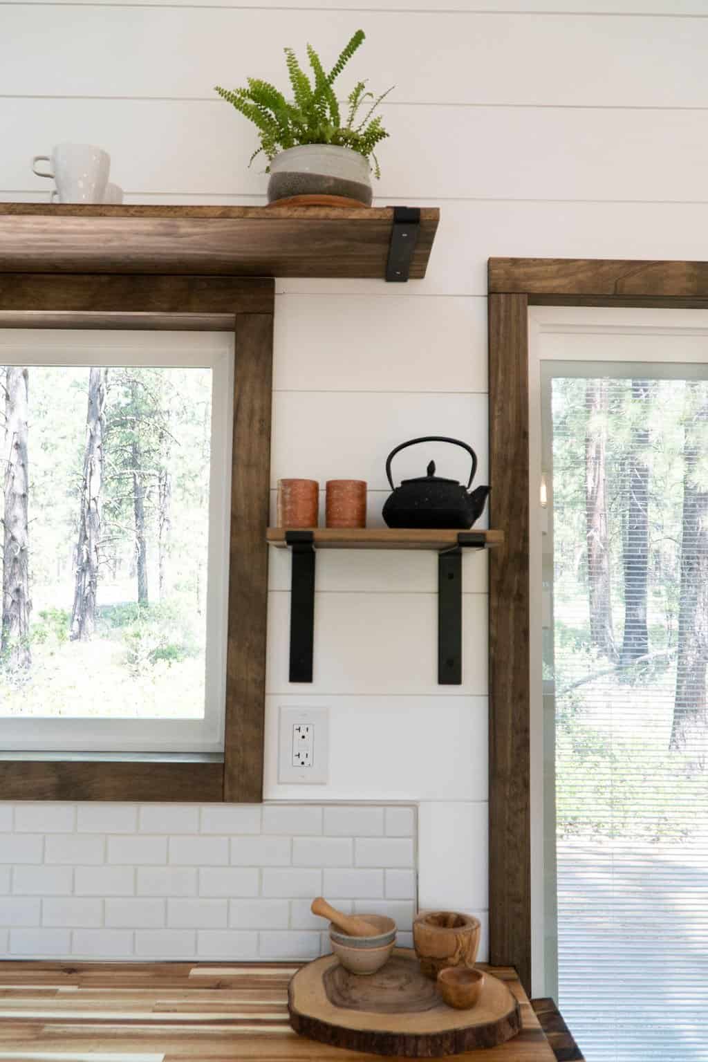Floating reclaimed wood shelves with a plant and teapot beside the Olympic's sliding glass door