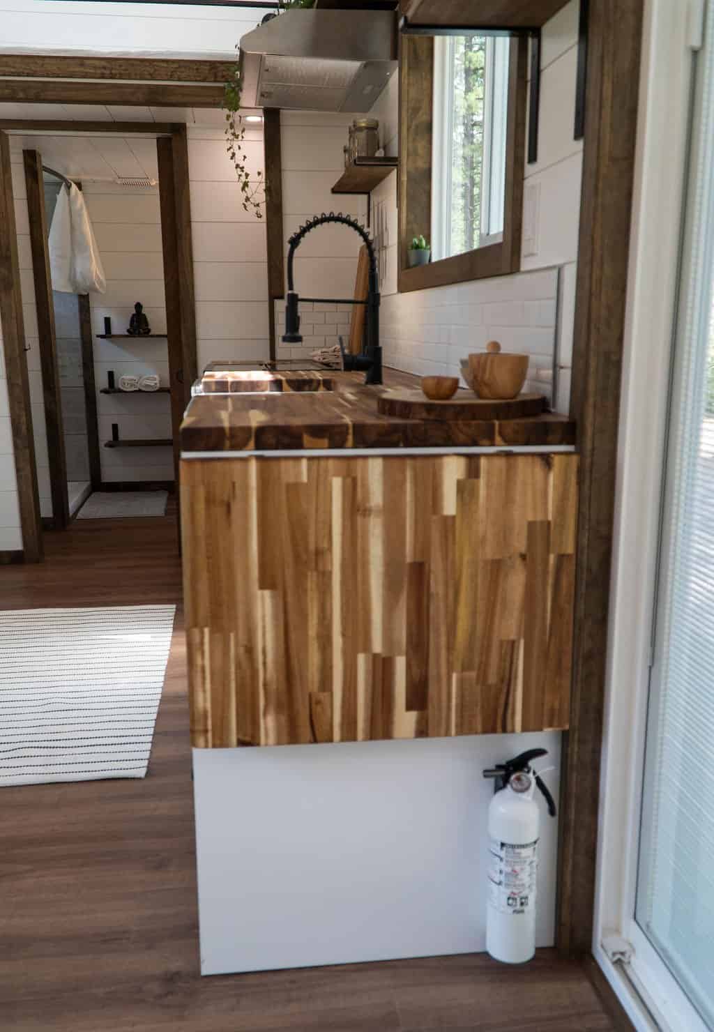 The Olympic kitchen with acacia butcher block counters, a porcelain farmhouse sink, and a gooseneck faucet