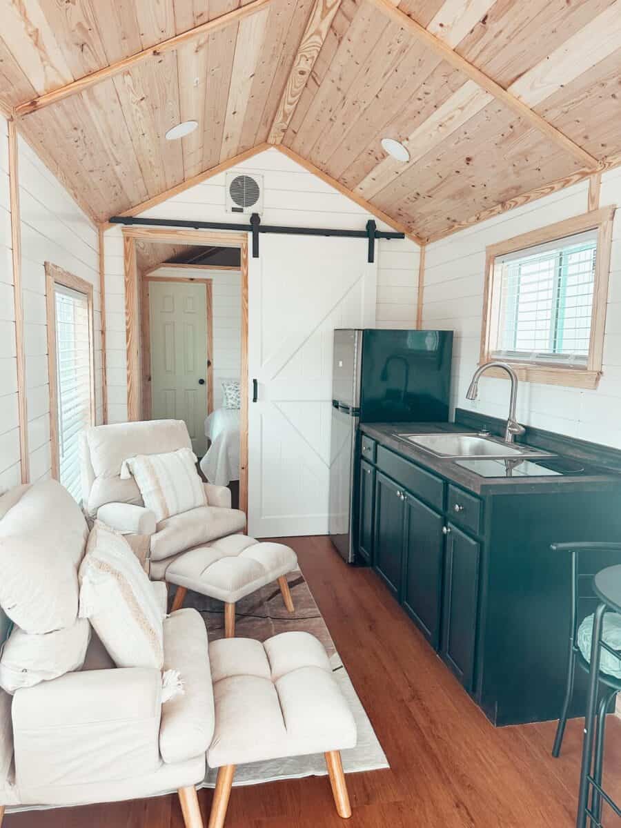 Cozy interior of The Phoenix tiny house featuring a compact kitchen and comfortable seating area.