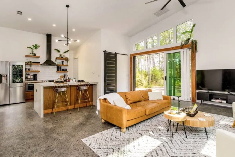 Bright, airy pine house interior featuring a cozy living room, modern kitchen, and expansive windows.