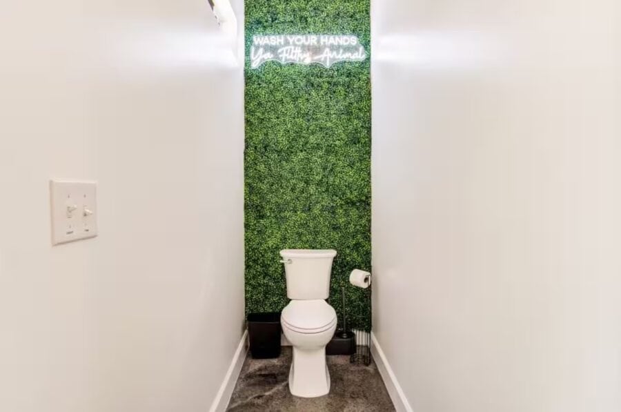 Modern bathroom with green wall and minimalist decor in a tiny house.
