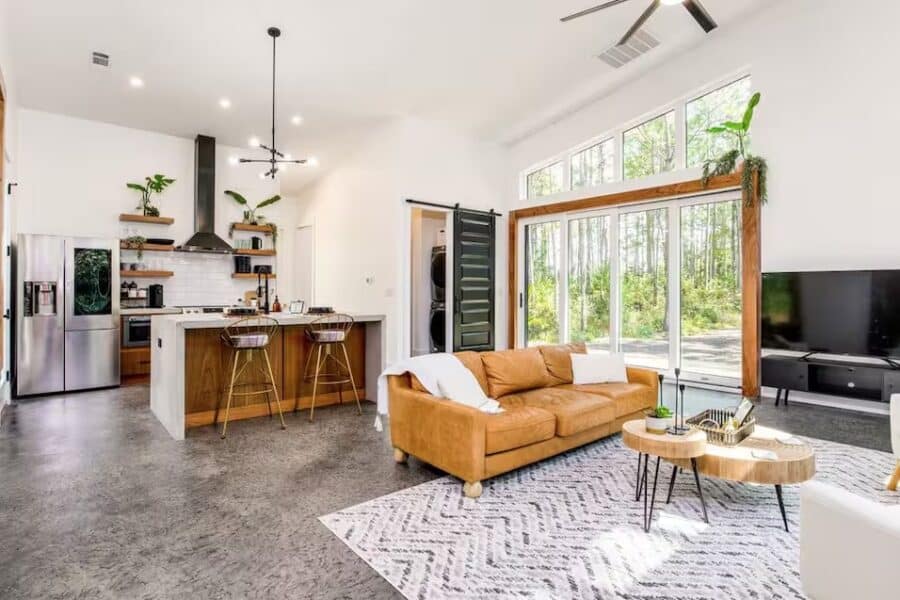 Bright living room with large windows and cozy sofa in Pine House, Pace, Florida.