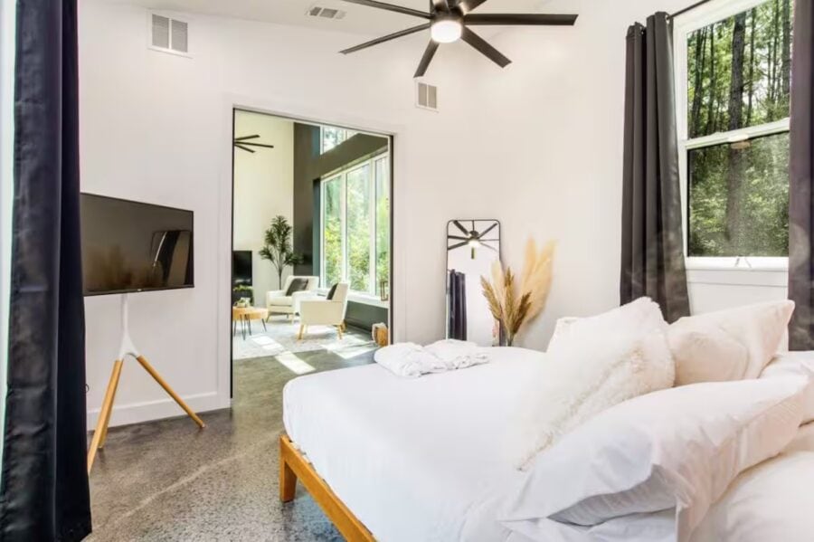 Modern Pine Cabin interior with bright, airy design and large windows showcasing lush forest views.
