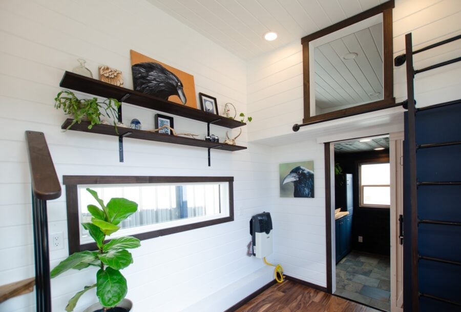 Bright tiny house interior featuring white walls, wooden accents, and stylish decor elements.