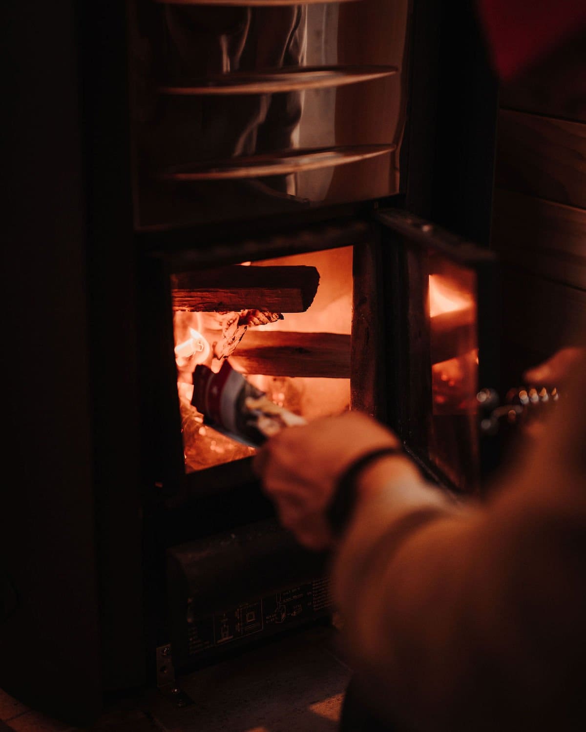 Feeding firewood into the River West sauna's wood-fired Harvia stove