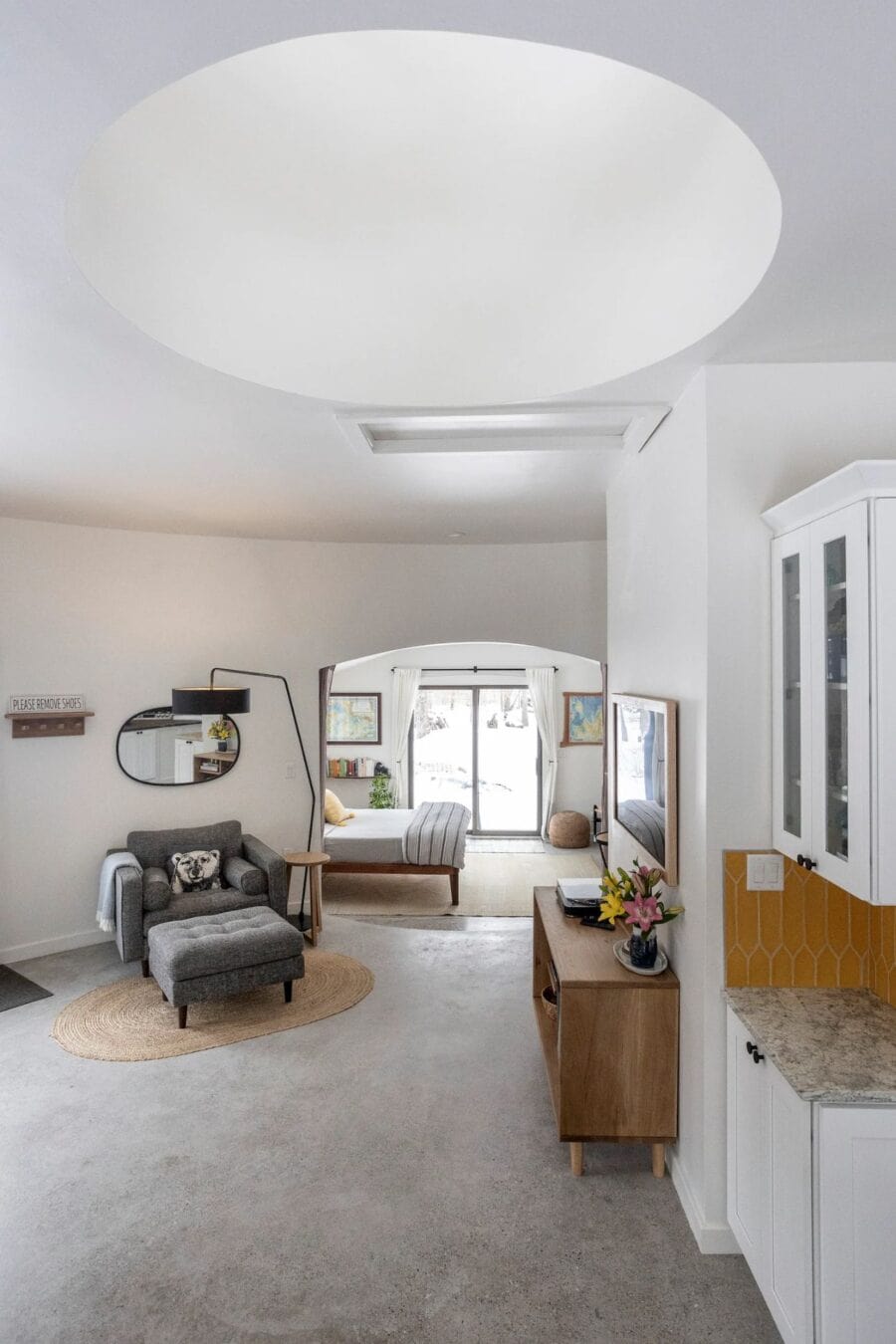 Circular tiny house living room with modern furniture and large windows.