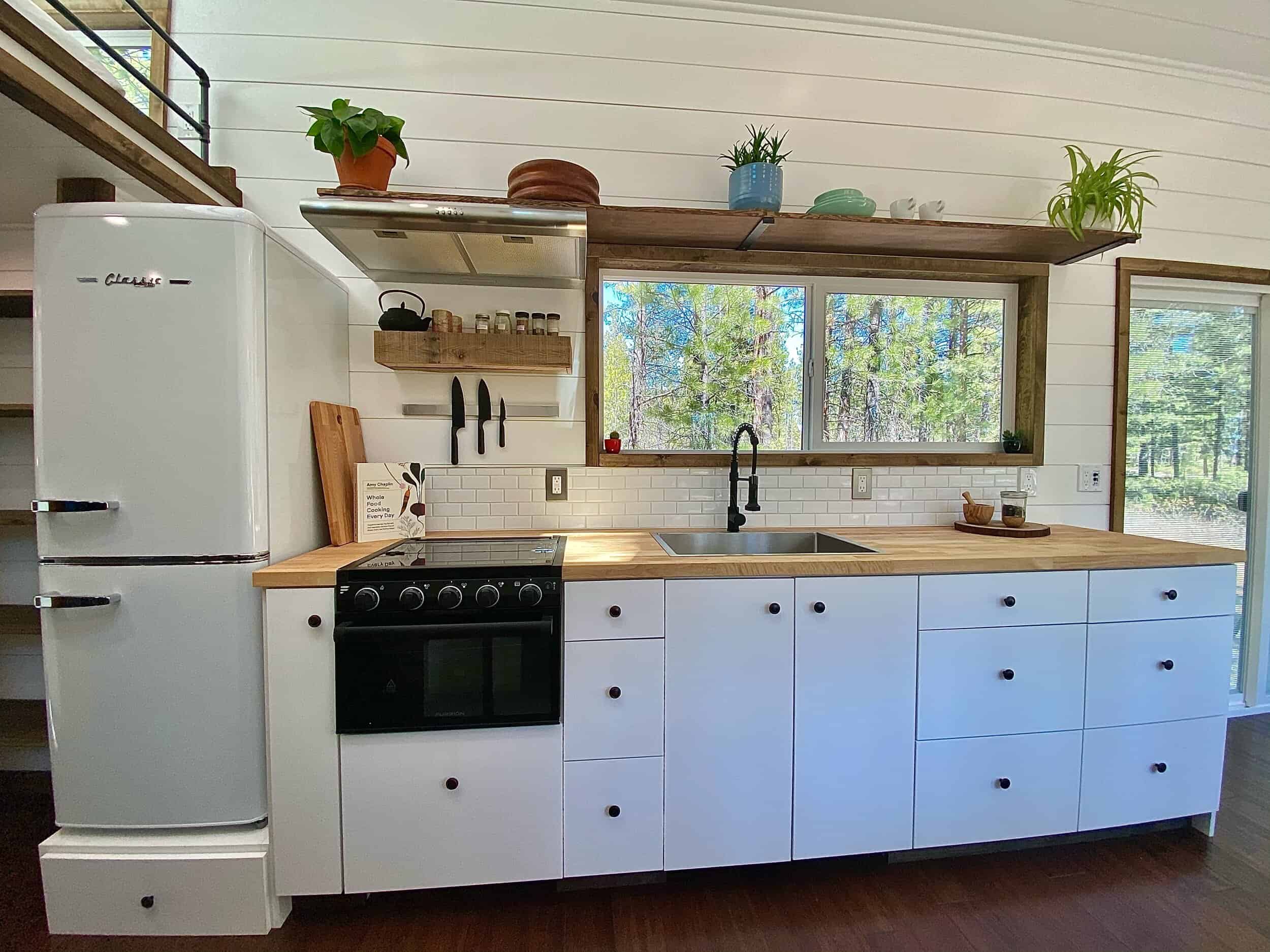 The Sonoma kitchen with white cabinets, butcher block counters, a gas range, subway tile, and a retro Classic refrigerator