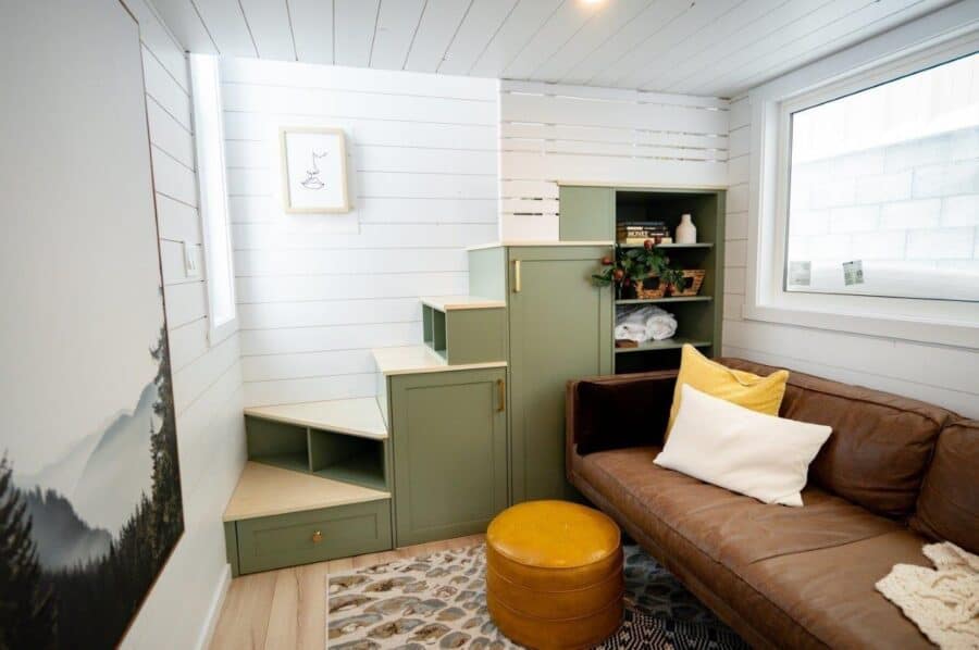 Green storage and seating area in a tiny home interior.
