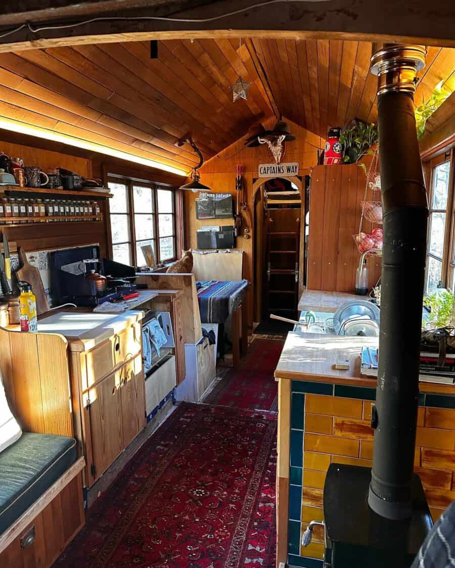 Charming tiny house built inside a cedar shake truck with wooden accents and compact kitchen space.