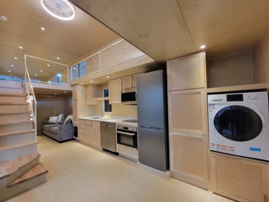 Bright tiny house kitchen featuring efficient appliances and minimalist design for small space livin.