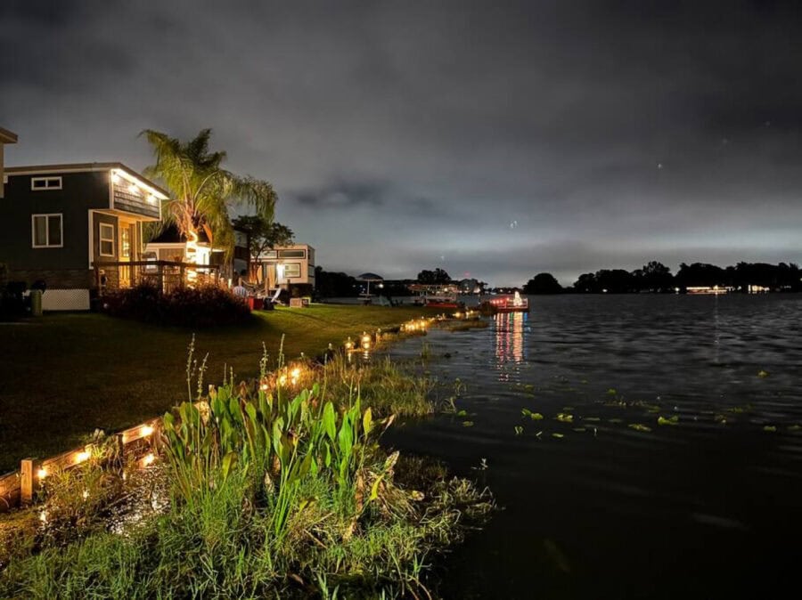 Charming lakefront tiny house in Orlando with beautiful water views and cozy outdoor lighting.
