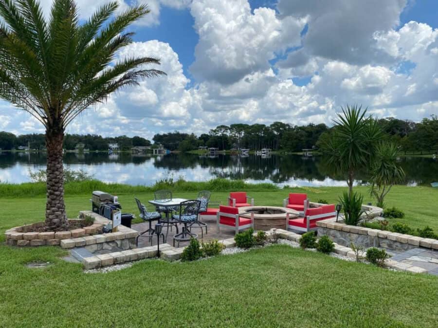 Lakefront tiny house outdoor patio with seating and palm trees in Orlando, Florida.