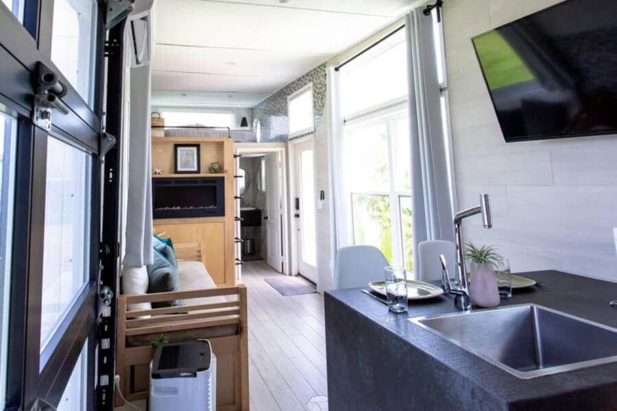 Compact lakefront tiny house with modern kitchen and cozy living space.