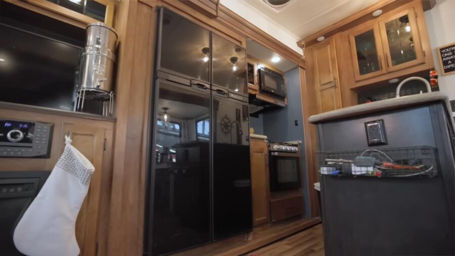 Cozy tiny house kitchen with modern appliances and wooden accents.