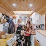 Family enjoying their tiny house with kids' bunk room and cozy interior.
