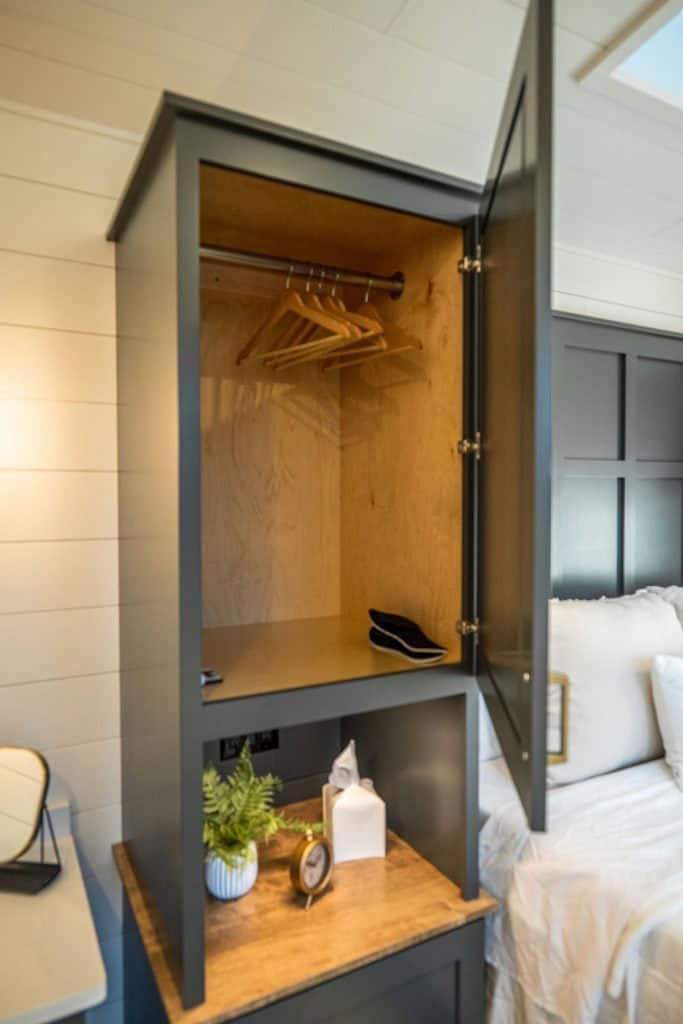 Modern Highland Cottage Closet with wooden interior and hanging space.