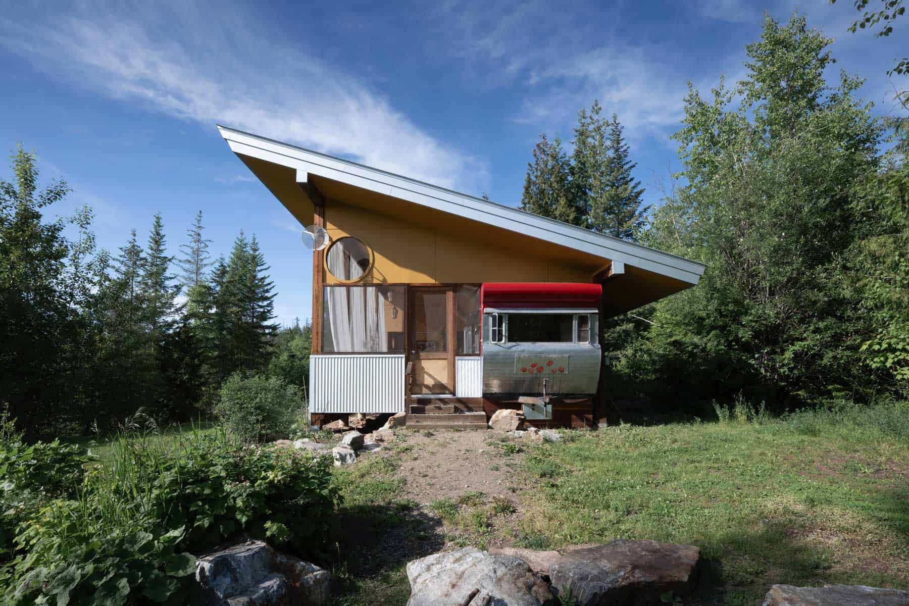 Tin Poppy Cabin exterior, a 1953 vintage mobile home enclosed in a screened structure in the Larch Hills near Salmon Arm, BC