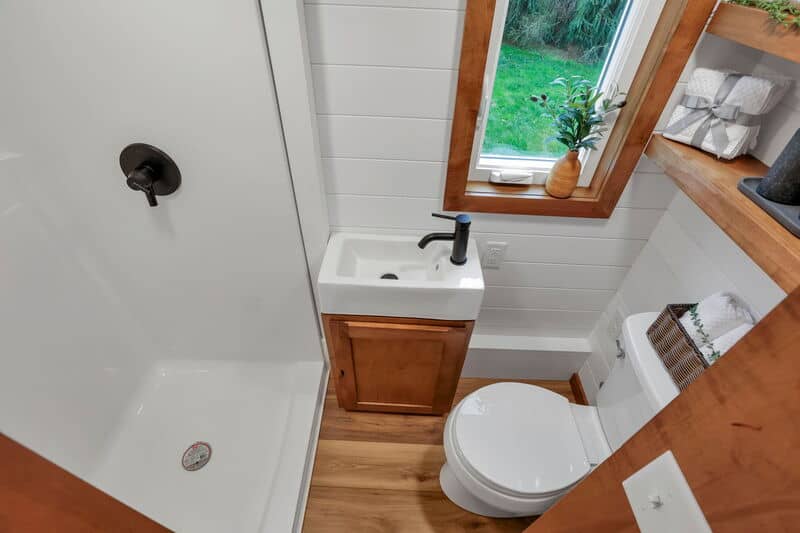 Tink bathroom with glass bi-fold shower enclosure Kohler flush toilet and custom vanity