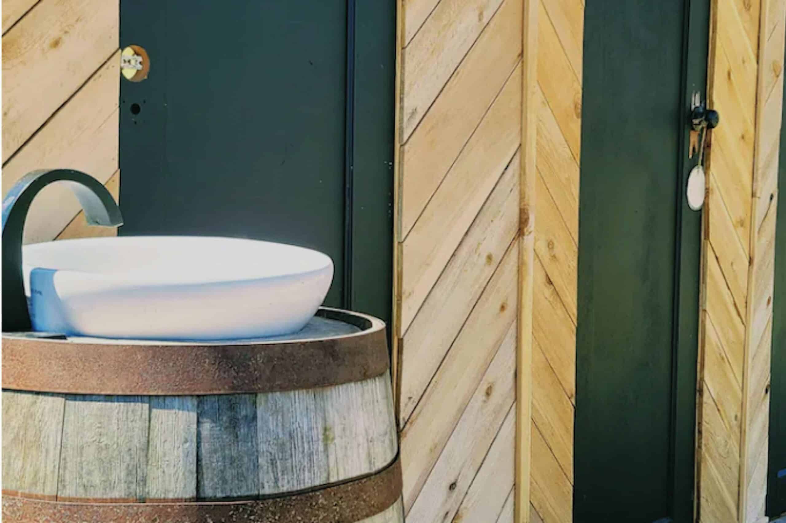Wine barrel vessel sink outside the cedar bathhouse at the A-frame cabin property