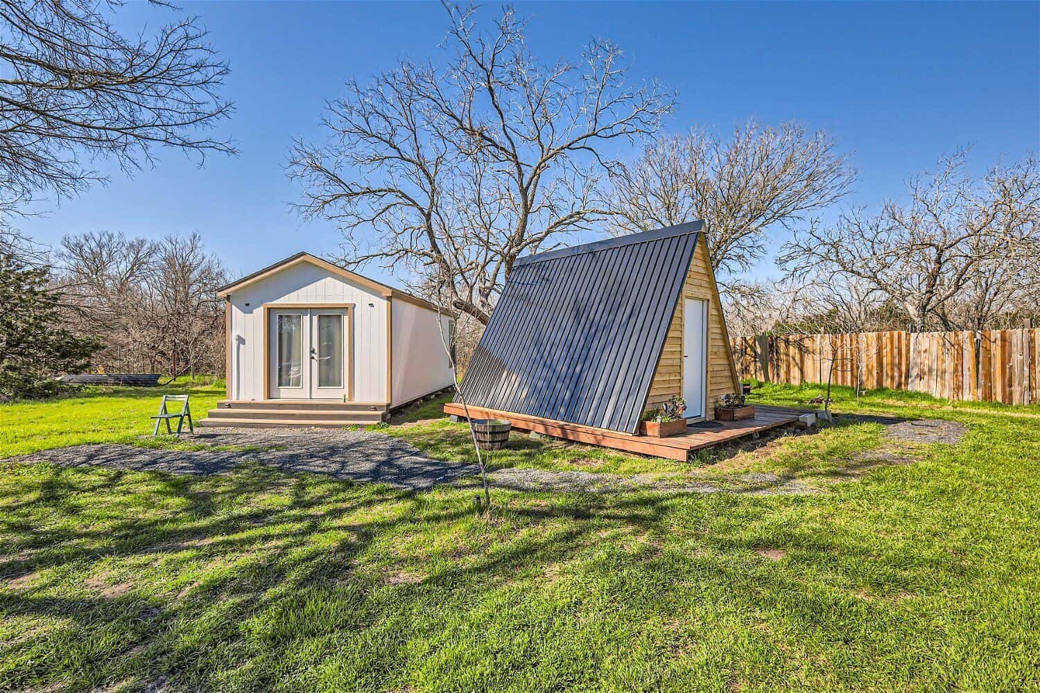 Wide view of the A-frame cabin and main building on 5 acres of green countryside near Austin Texas
