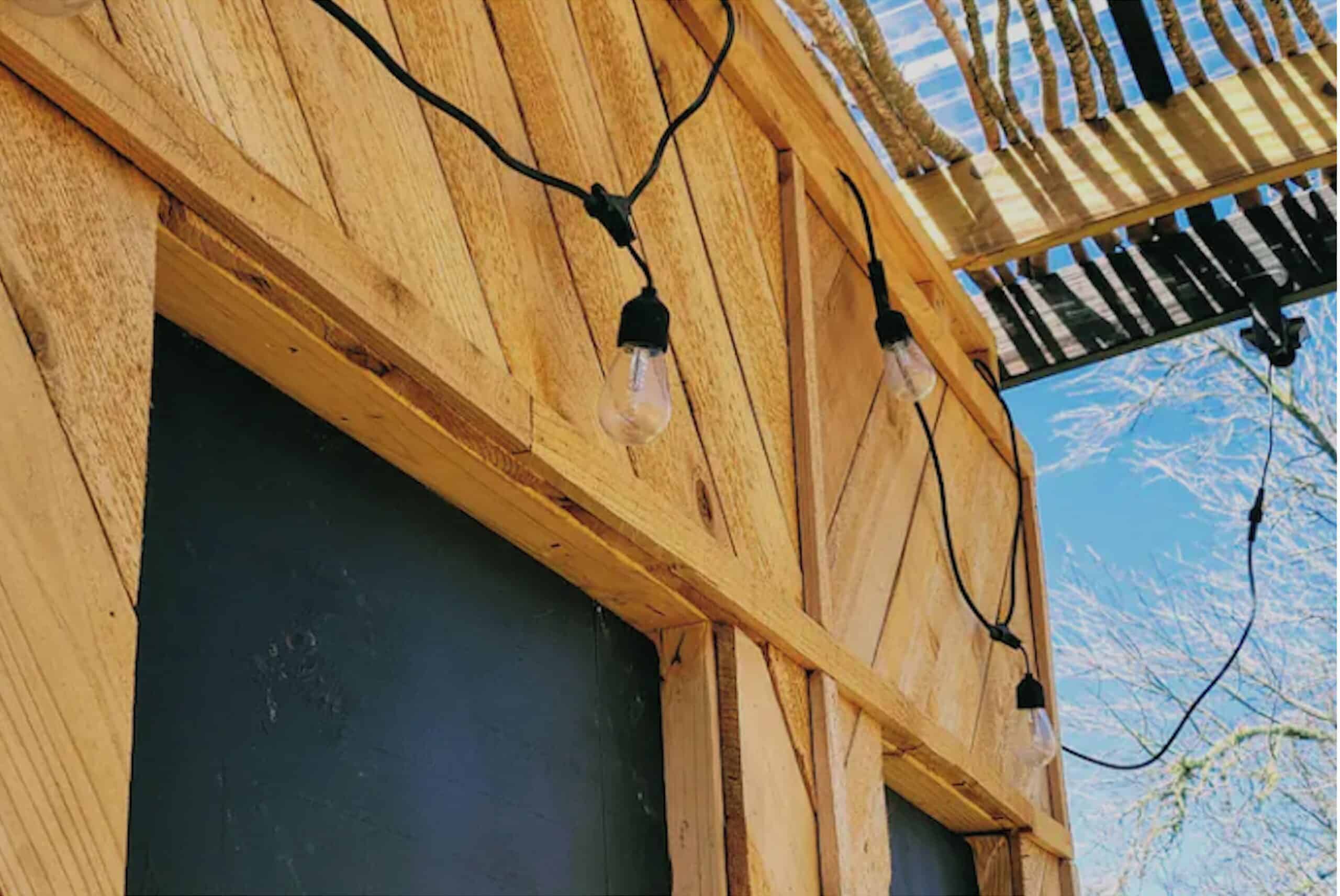 String lights and wood detail on the tiny A-frame cabin exterior near Austin Texas