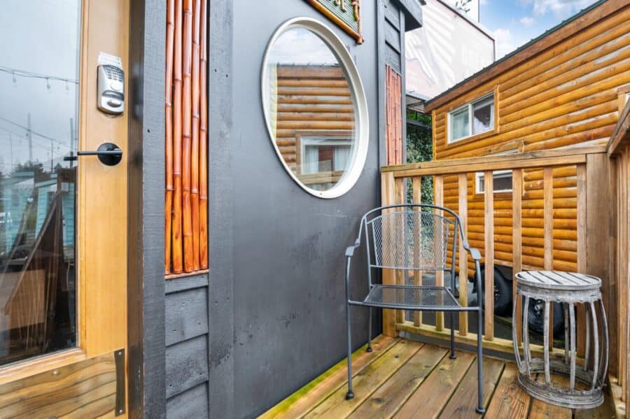 Round porthole window and small deck outside the Bamboo tiny house at Tiny Digs