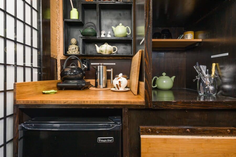 Teapots and kitchenette shelves beside a Shoji screen in the Bamboo tiny house