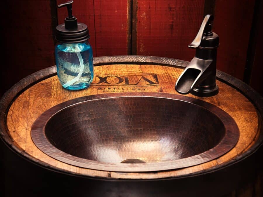 Hammered copper sink on a whiskey barrel vanity at the Barn tiny house