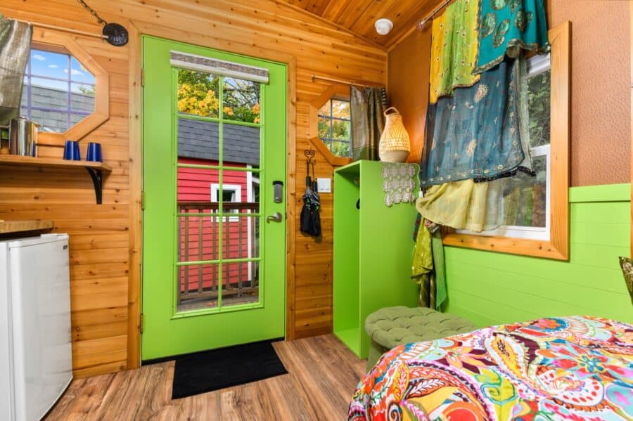 Lime green front door and colorful fabrics inside the Boho Wagon tiny house