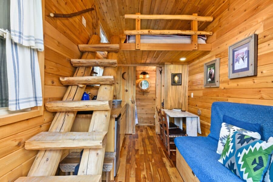 Hand-hewn log stairway to the sleeping loft inside the Cabin tiny house at Tiny Digs