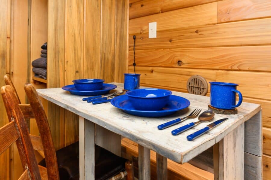 Blue enamel camp dishes on the dining table of the Cabin tiny house