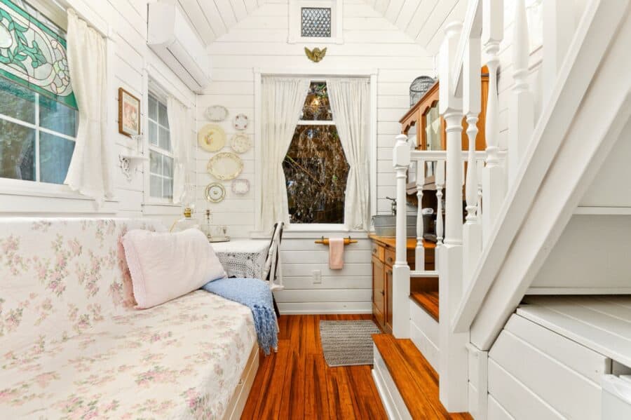 Floral daybed and white interior of the Victorian Cottage tiny house