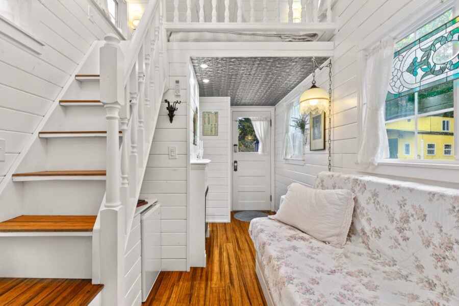 White staircase with turned balusters inside the Cottage tiny house