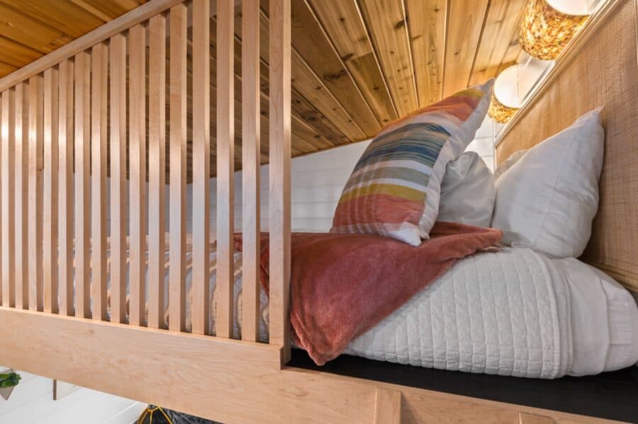 Queen bed in the cedar-lined sleeping loft of the Finlandia tiny house