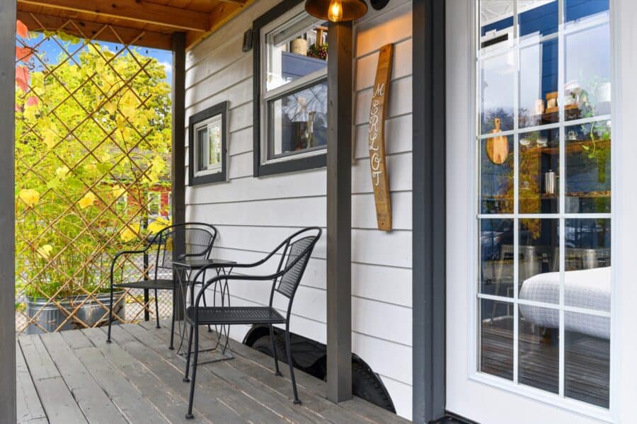 Bistro table on the wrap-around deck beside the French doors of the Merlot tiny house