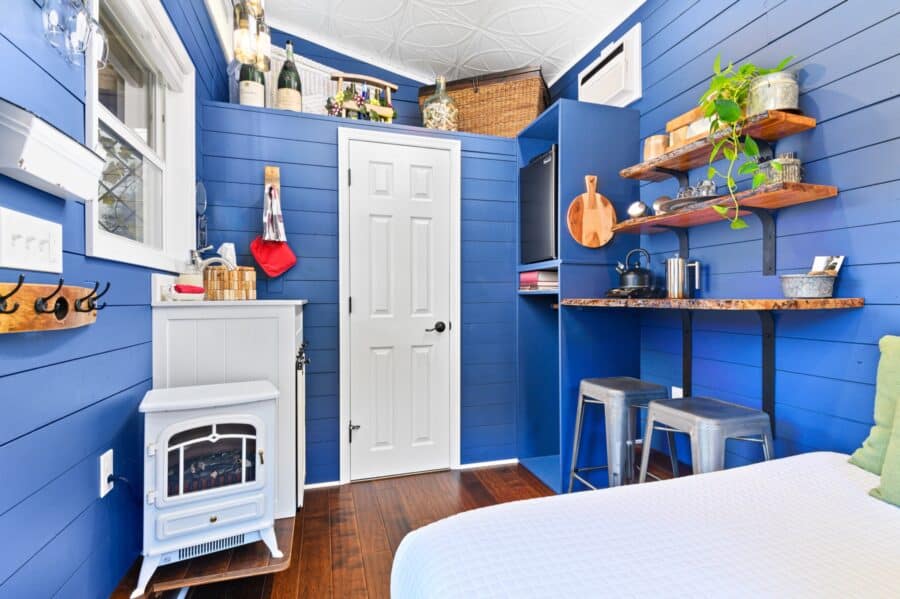 Navy blue interior with white electric stove and kitchenette in the Merlot tiny house