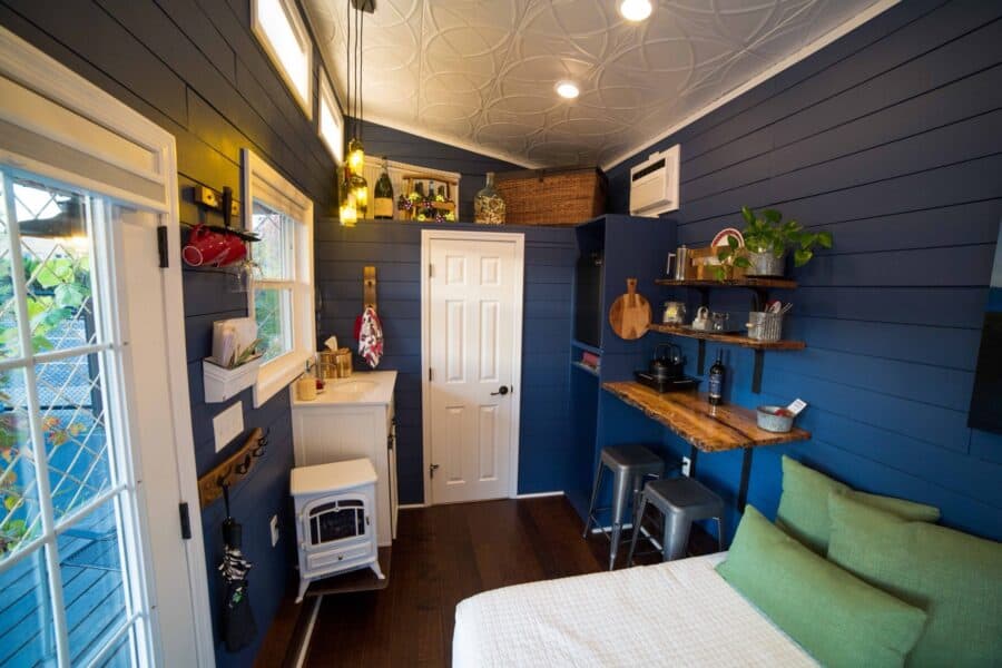 Long view of the Merlot tiny house interior with bed, desk, and vaulted ceiling