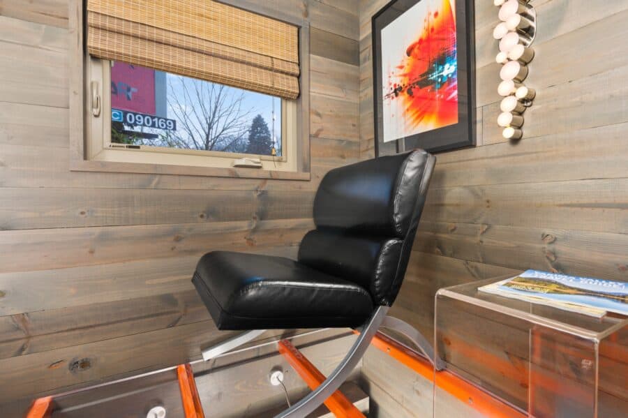 Black leather lounge chair on the clear acrylic loft of the Modern tiny house