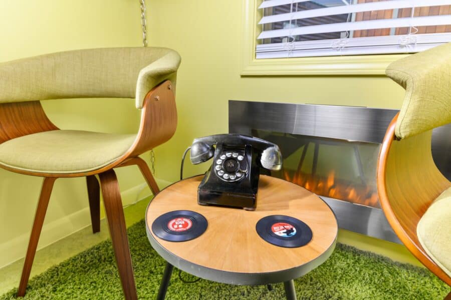 Rotary phone and vinyl records on a table in front of the fireplace at the Rock n Roll tiny house